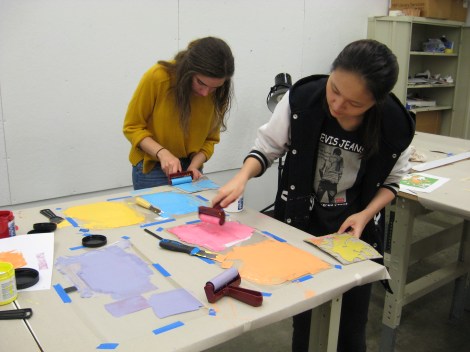 photo of two people rolling out colorful relief printing ink