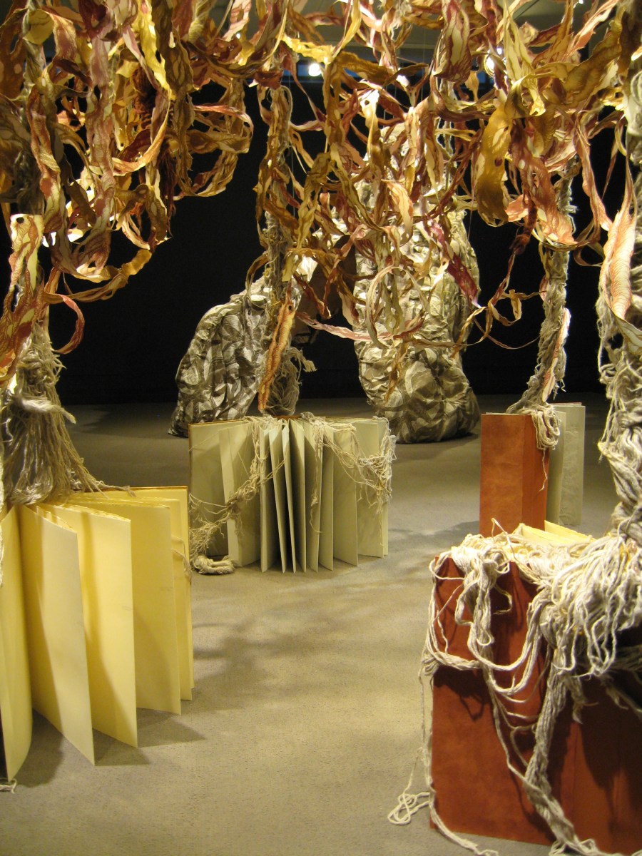 installation detail: books with draped yarn roots